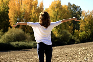 Woman outdoors in autumn, enjoying nature and embracing a calm, natural wellness lifestyle.