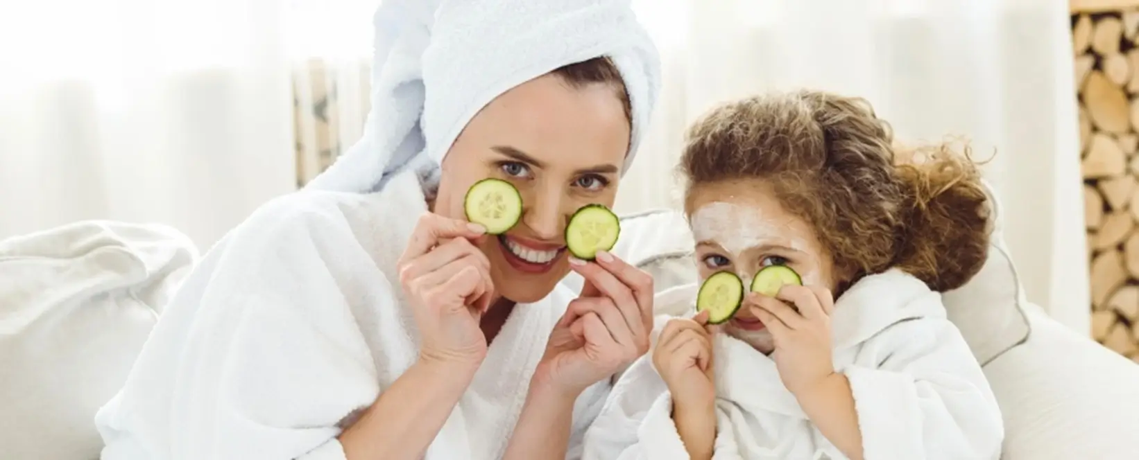 lady and a girl covering their eyes with cucumber pieces 